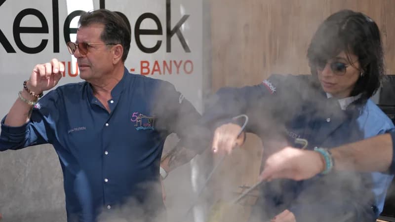 Şef, buharı tüten tencerenin başında tarifi anlatıyor